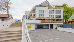 un gran edificio blanco con una escalera delante en Gea Eco Appartment 200m von Ostsee WiFi mit incl Parkplatz en Sianozety