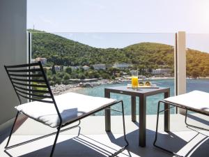 a balcony with a table and chairs and a view of the water at Hotel Kompas in Dubrovnik
