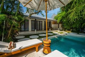 an umbrella over a swimming pool in a villa at Berapi Villa by EVDEkimi - Modern Ubud Villa with Private Pool & Modern Kitchen - New Year's Offer in Ubud