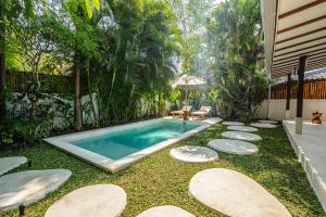 a swimming pool in the middle of a yard at Berapi Villa by EVDEkimi - Elegant 3BR Ubud Home with Pool & Kitchen near Central Ubud in Ubud