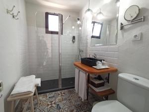 a bathroom with a shower and a toilet and a sink at LA JARANA Casa Hotel in Zahara de la Sierra +17 photos