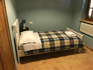 1 dormitorio con 1 cama con manta a cuadros en Antico Casale San Lorenzo, en Colle San Lorenzo