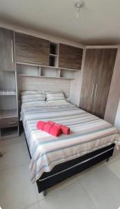 a large bed with two red pillows on it at Apartamento Farolandia in Aracaju