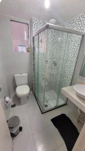 a bathroom with a shower and a toilet and a sink at Apartamento Farolandia in Aracaju