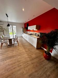 cocina con mesa y pared roja en Maison coeur de ville Montchanin, en Montchanin