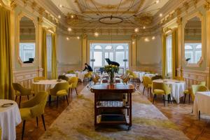 a dining room with tables and yellow chairs at Vila Foz Hotel & SPA in Porto