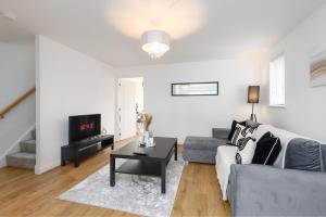 a living room with a couch and a table at New Modern Luxury Cosy Home In Canterbury - Free Parking EV - Sleeps 7 in Sturry