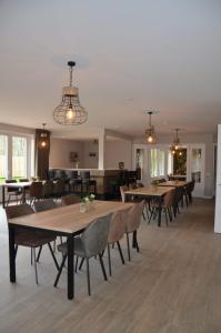 a dining room with tables and chairs and a couch at Vakantiehuis B&B Familie Versantvoort in Handel