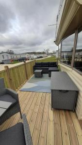 a patio with a couch and chairs on a deck at 7 Lakes Country Park, 38 Sunset View in Crowle