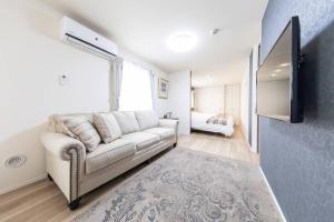 a living room with a white couch and a window at Logement Aile 101 in Takasaki