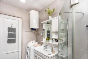 a white bathroom with a sink and a shower at Coastal Oasis - Sea View Porta Batumi 2 bedroom apartment in Batumi +67 photos
