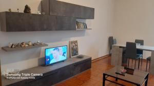 uma sala de estar com uma televisão e uma mesa com cadeiras em casa Dany em Perugia