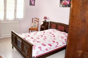 a bedroom with a bed with pink flowers on it at Maison de 3 chambres avec jardin amenage a Montbron in Montbron