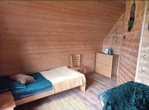 a bedroom with a bed and a wooden wall at Dwa Klimaty in Myczkowce