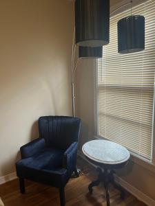 une chambre avec une chaise, une table et une lampe dans l'établissement The Peacock Cottage, à San Marcos