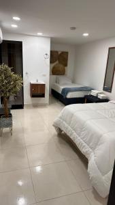 a large bedroom with two beds and a table at 33 HOTEL BOUTIQUE in Medellín