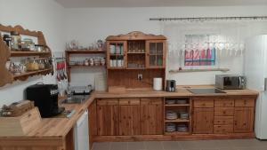 uma cozinha com armários de madeira e uma bancada em Dworek pod świerkami em Jelenia Góra