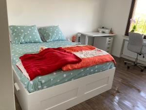 ein Bett mit einer roten Decke darauf in einem Schlafzimmer in der Unterkunft Nice Cozy Appartment Remich in Remich