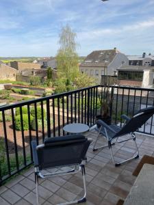 a patio with two chairs and a table on a balcony at Nice Cozy Appartment Remich in Remich