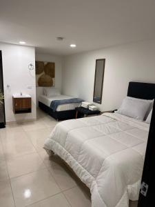 a hotel room with two beds and a table at 33 HOTEL BOUTIQUE in Medellín