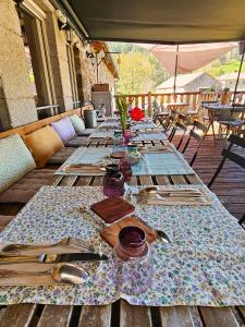 a long table with plates and utensils on a patio at Auberge de Chanteuges in Chanteuges