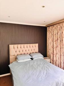 a bedroom with a large bed with two pillows at Family Home, Hillcrest in Gillitts +4 photos