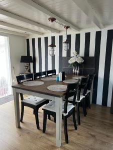 una sala da pranzo con tavolo e sedie di Charmantes Ferienhaus in Wervershoof mit Terrasse und Grill a Wervershoof