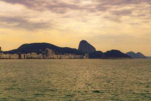 una vista del océano con montañas en el fondo en Amelie Poulin Apartamento Beach, en Río de Janeiro