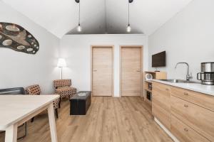 uma cozinha e sala de estar com um lavatório e uma mesa em Rauðafell apartment em Hvolsvöllur