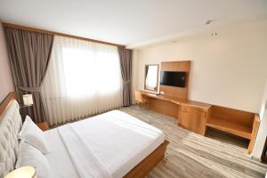 a hotel room with a bed and a television at Hotel La Villa in Gjakove