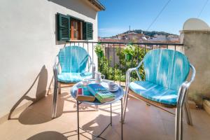2 Stühle und ein Tisch auf dem Balkon in der Unterkunft Townhouse Lleo 72 By homevillas360 in Pollença