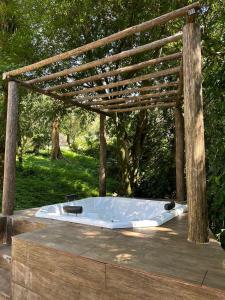een hot tub onder een houten pergola bij Sítio com piscina e churrasqueira in Guapimirim