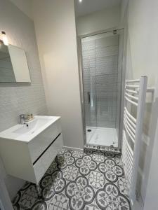 uma casa de banho branca com um lavatório e um chuveiro em Studios Climatises en centre Ville em Bordeaux