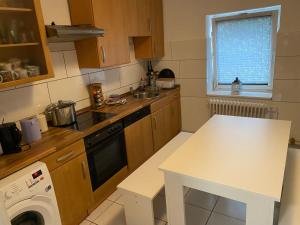 een kleine keuken met een witte tafel en een wastafel bij Monteurroom 1 Hannover-Ronnenberg in Ronnenberg