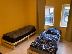 a room with two beds and a bed and two windows at Monteurroom 1 Hannover-Ronnenberg in Ronnenberg