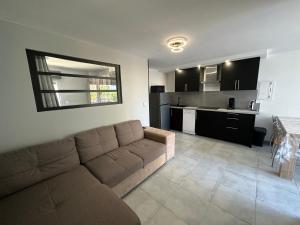 Una sala de estar con un sofá y una cocina. en Appartement T2, en Saint-Cyprien