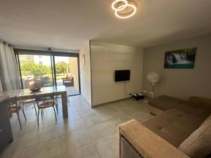 una sala de estar con un sofá y una mesa en Appartement T2, en Saint-Cyprien