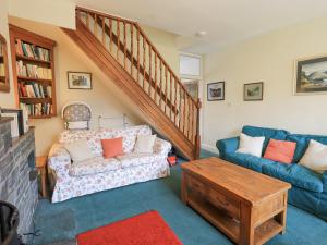 - un salon avec un canapé et un escalier dans l'établissement Holme Ground Cottage, à Coniston
