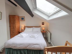 - une chambre avec un lit blanc, 2 tables et une fenêtre dans l'établissement Holme Ground Cottage, à Coniston