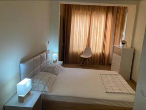 een slaapkamer met een groot wit bed en een raam bij golden sands flat 147 in Goudstrand