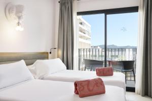 サンアントニオにあるStic Urban Hotel & SPAのベッド2台とバルコニーが備わるホテルルームです。