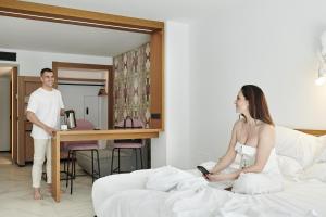 un hombre y una mujer sentados en una cama en Stic Urban Hotel & SPA, en San Antonio