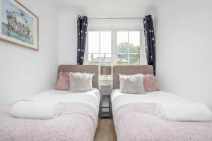 two beds in a room with a window at Detached Luxury Stylish House - Staycation - Hot Tub in Warfield