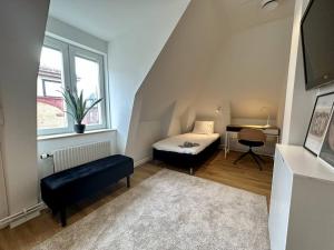 ein kleines Zimmer mit einem Bett und einem Schreibtisch in der Unterkunft Attic Hostel in Borås