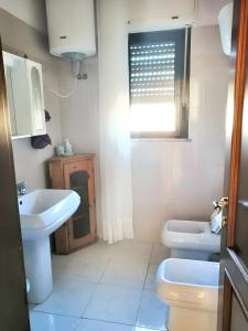 bagno con due servizi igienici, lavandino e finestra di 2 bedrooms apartement with balcony at Teulada a Teulada