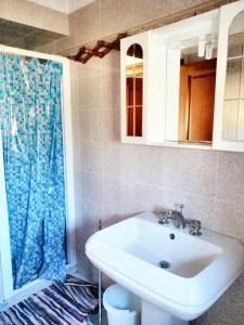 bagno con lavandino e tenda doccia blu di 2 bedrooms apartement with balcony at Teulada a Teulada