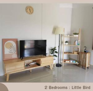 a living room with a flat screen tv on a wooden entertainment center at Betong House in the Garden in Betong