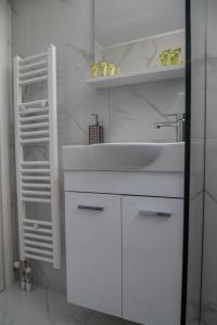 a white bathroom with a sink and a shelf at Central apartment near to Acropolis area in Athens