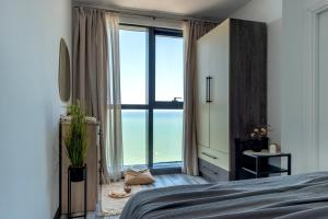a bedroom with a bed and a large window at Coastal Oasis - Sea View Porta Batumi 2 bedroom apartment in Batumi