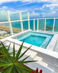 a swimming pool on top of a building with the ocean at Seara Praia Hotel in Fortaleza